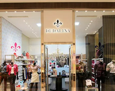 Fachada de uma loja Dudalina em shopping, com roupas na vitrine
